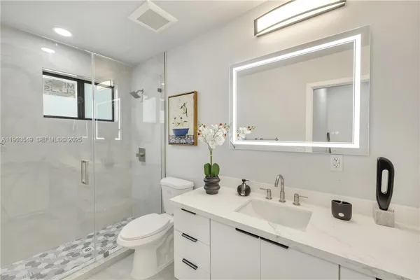 a bathroom with a sink a toilet and shower