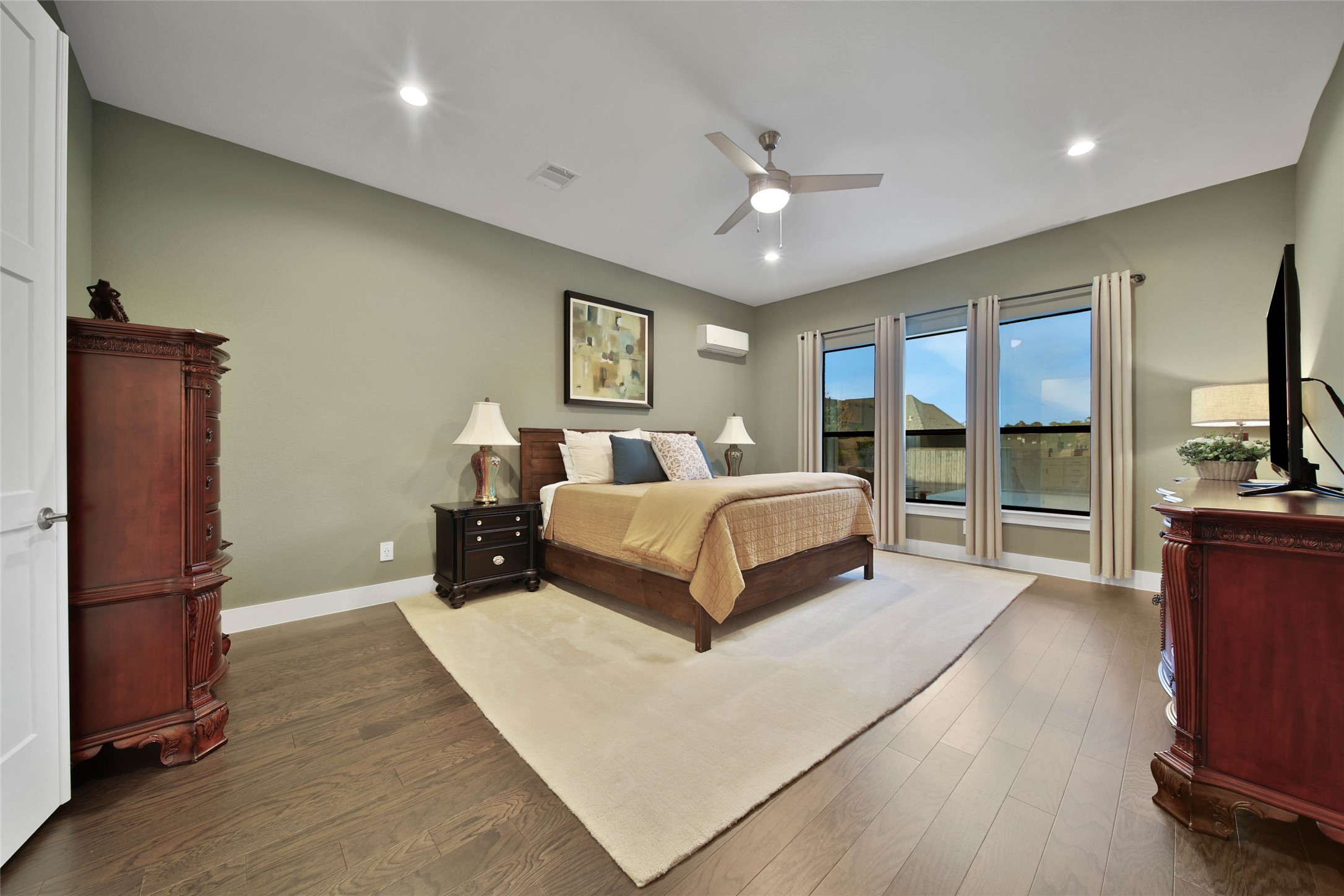 1015 Oak Briar Lane Conroe, TX 77384 - Photo 26 of 50 a bedroom with a large bed a flat tv screen and balcony