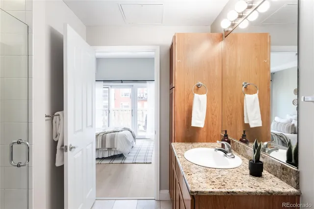 a en suite bathroom with a granite countertop sink and a mirror