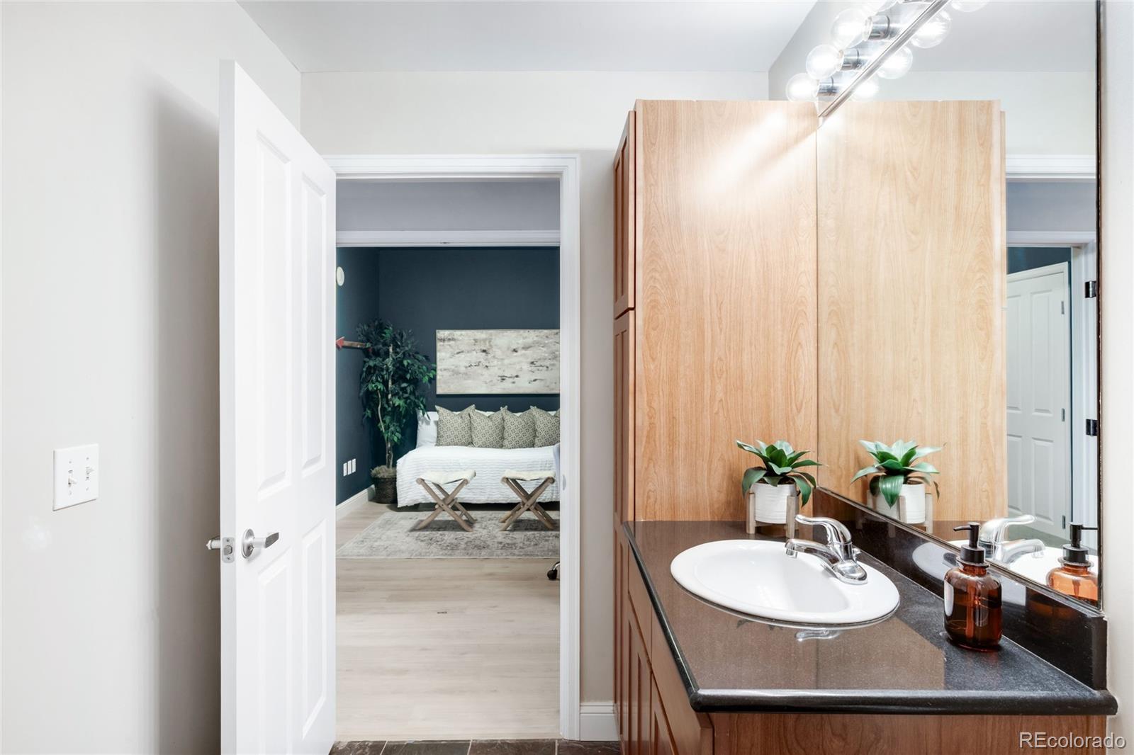 1950 Logan Street, Unit 901 Denver, CO 80203 - Photo 19 of 24 a en suite bathroom with a sink a mirror and a shower