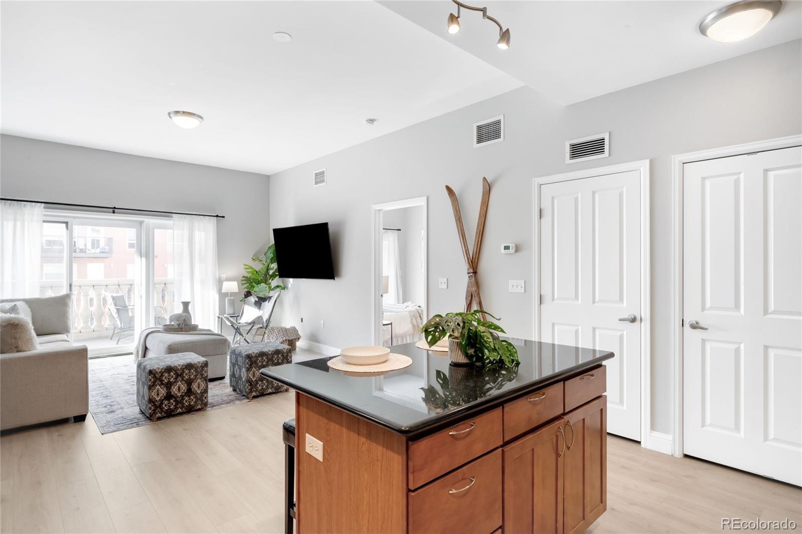 1950 Logan Street, Unit 901 Denver, CO 80203 - Photo 7 of 24 a living room with furniture a flat screen tv and a large window