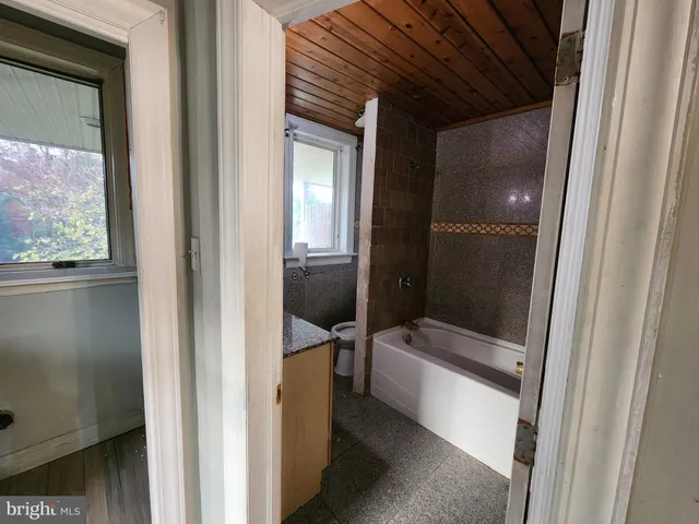 a kitchen with stainless steel appliances granite countertop a stove a sink and a refrigerator with wooden cabinets