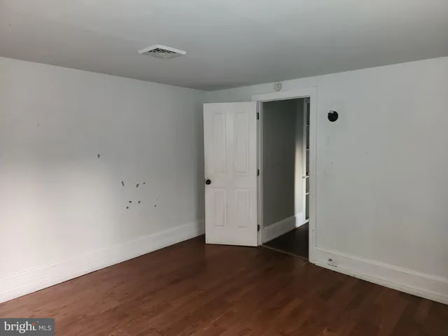 an empty room with wooden floor and closet