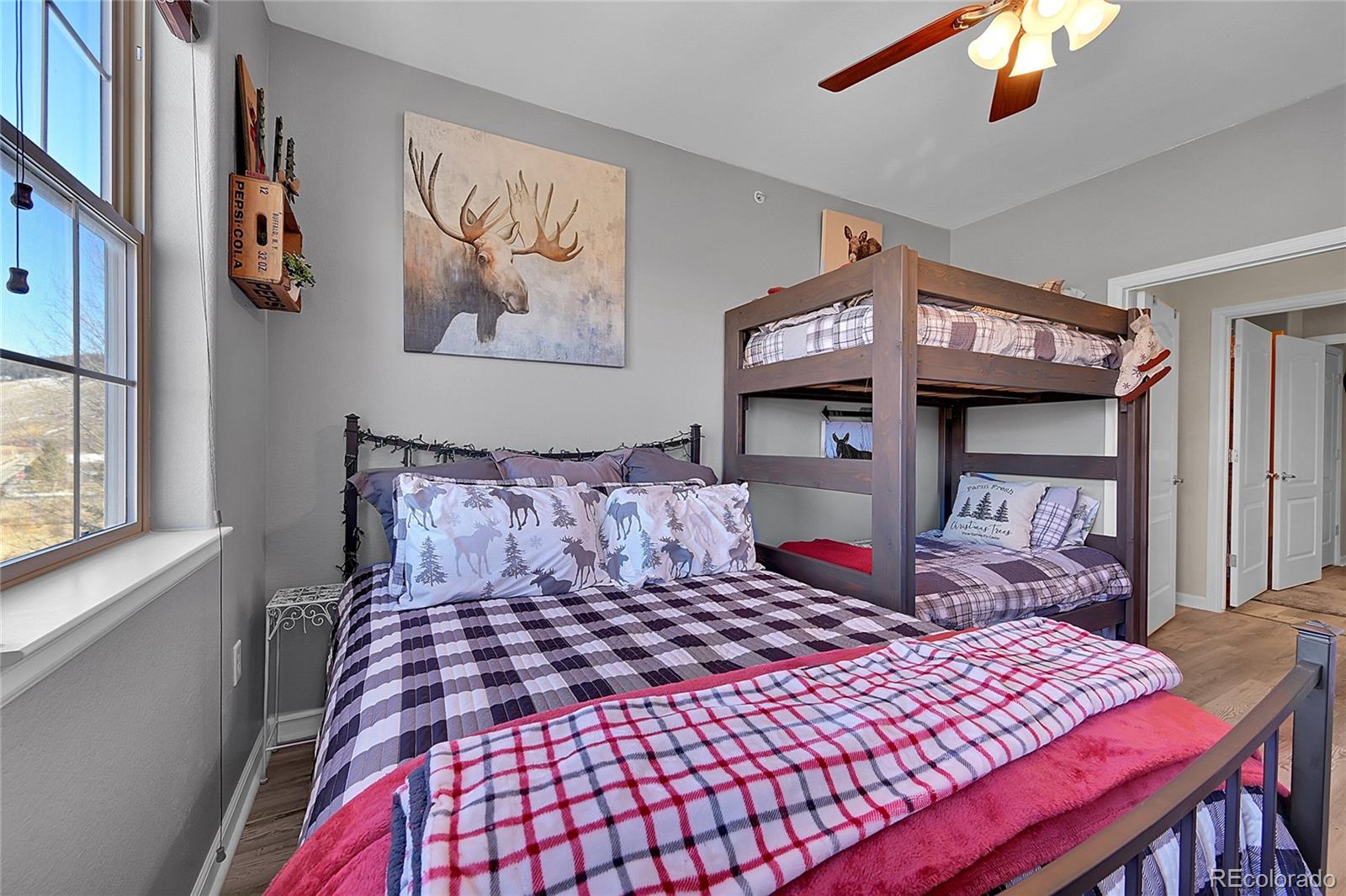 150 Village Road, Unit A302 Granby, CO 80446 - Photo 32 of 50 a bedroom with a large bed and a chandelier