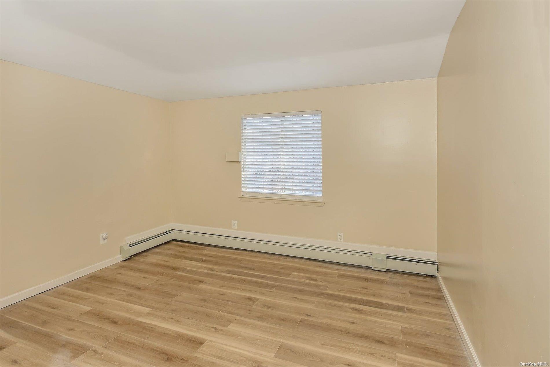 165-28 144th Drive Queens, NY 11434 - Photo 17 of 25 an empty room with wooden floor and windows