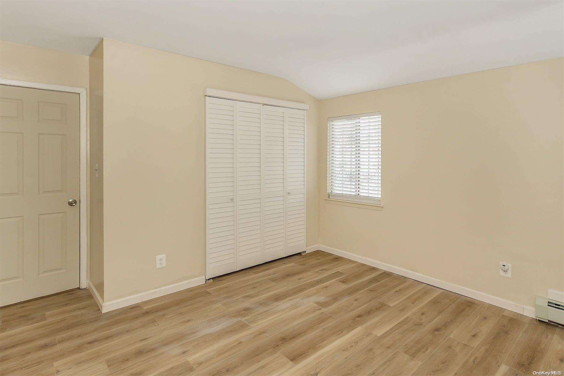 165-28 144th Drive Queens, NY 11434 - Photo 18 of 25 an empty room with wooden floor and windows