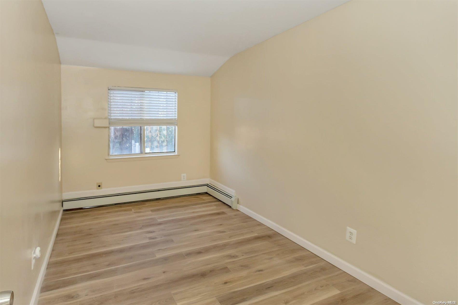 165-28 144th Drive Queens, NY 11434 - Photo 19 of 25 an empty room with wooden floor and windows