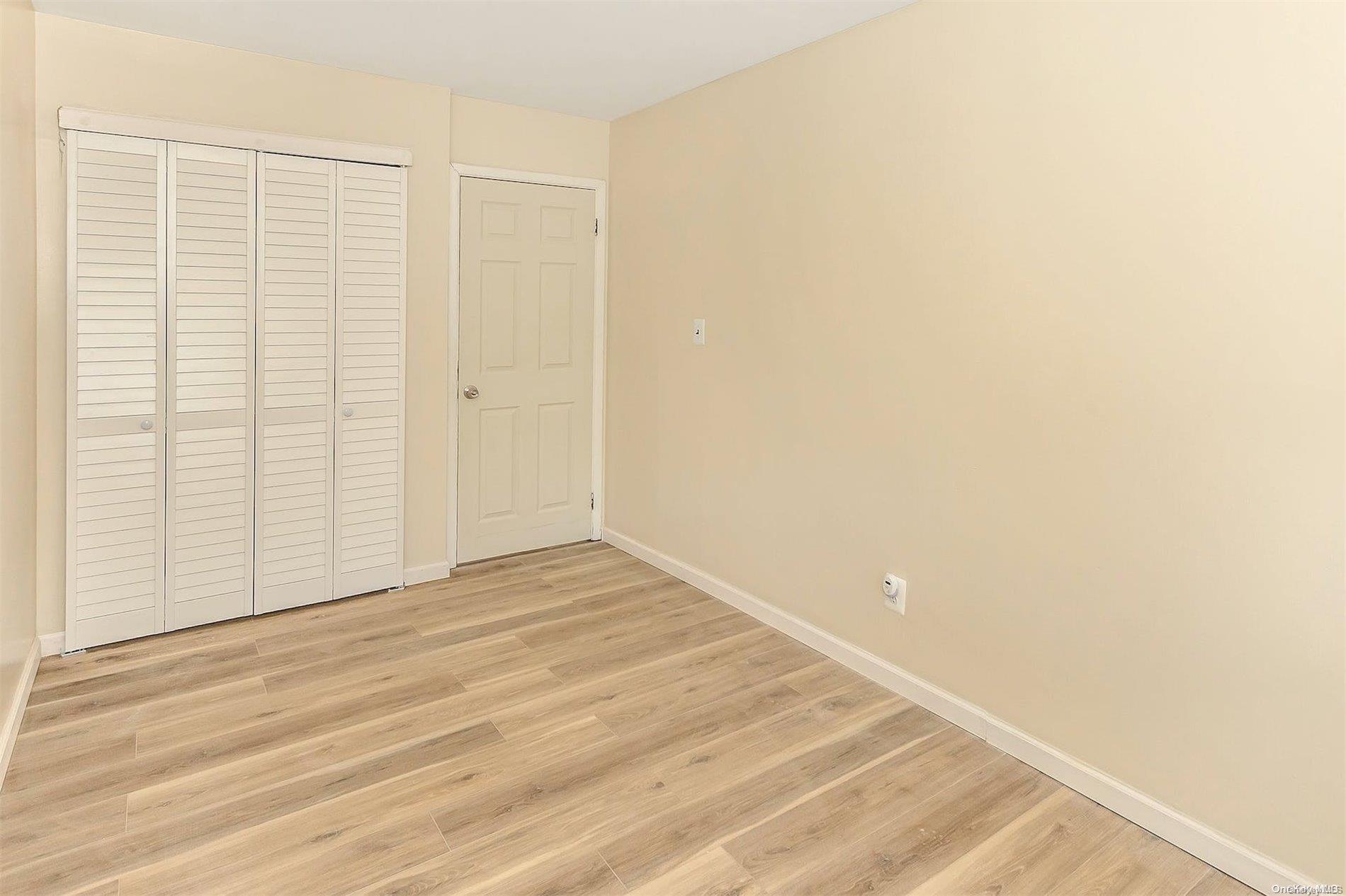 165-28 144th Drive Queens, NY 11434 - Photo 20 of 25 a view of an empty room with wooden floor