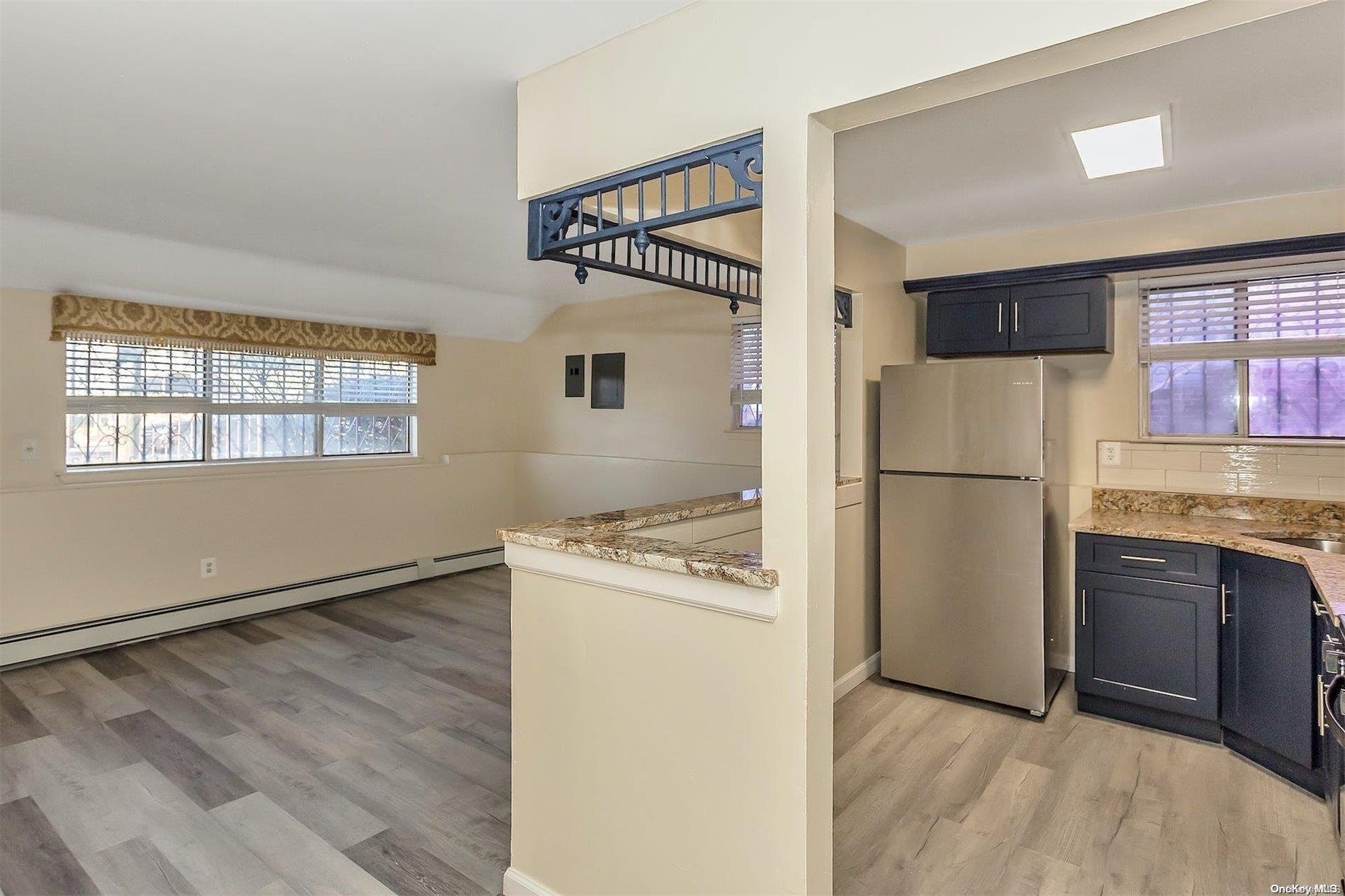 165-28 144th Drive Queens, NY 11434 - Photo 7 of 25 a kitchen with granite countertop a refrigerator and a stove top oven