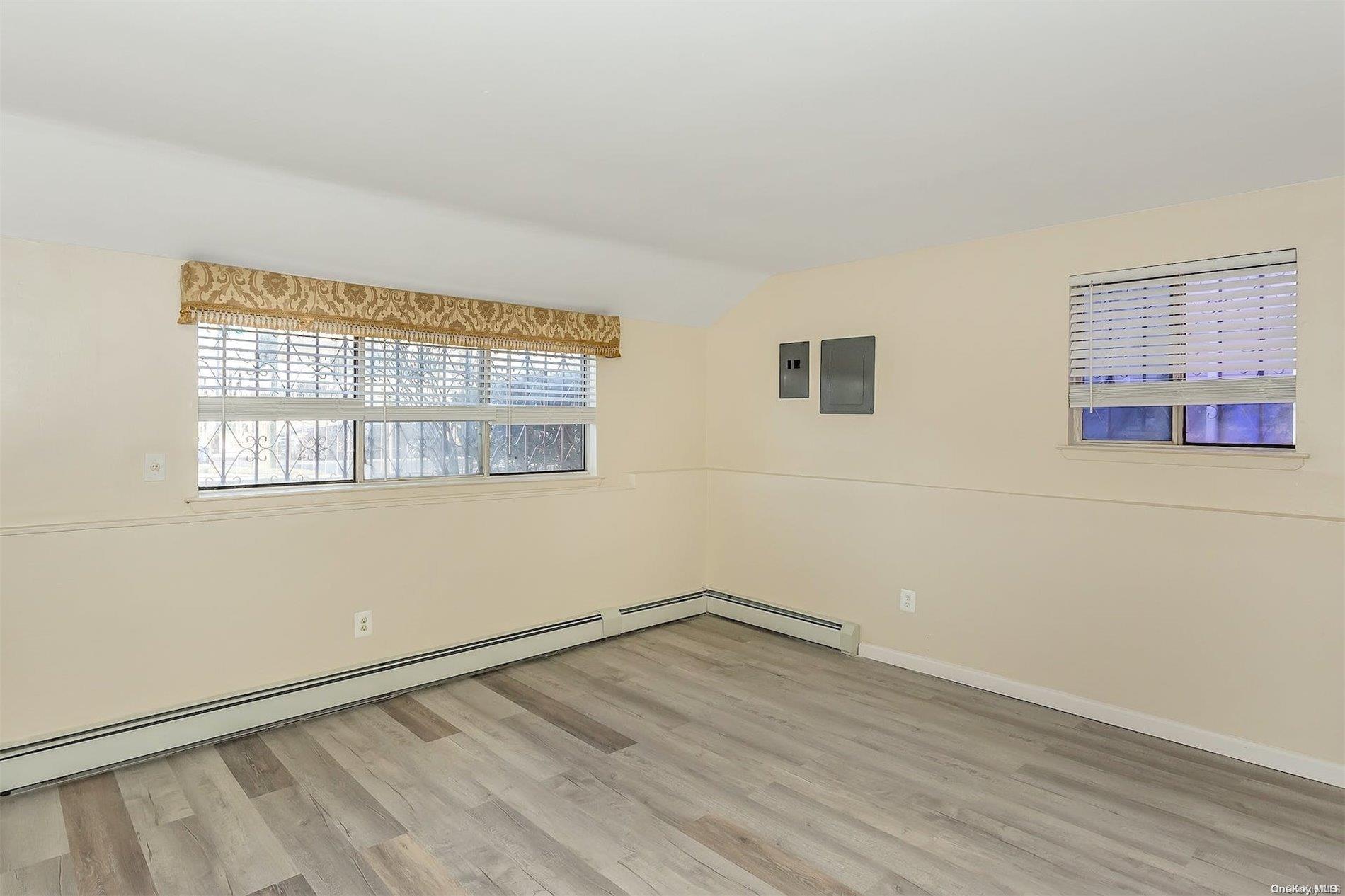 165-28 144th Drive Queens, NY 11434 - Photo 9 of 25 an empty room with wooden floor and windows