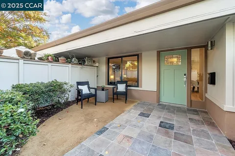 a view of a porch with chairs and potted plants