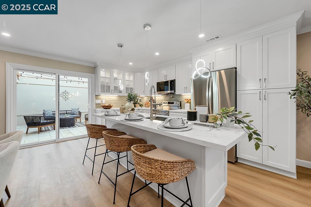 1180 Running Springs Road, Unit 4 Walnut Creek, CA 94595 - Photo 9 of 24 a kitchen with stainless steel appliances kitchen island granite countertop a sink and a refrigerator