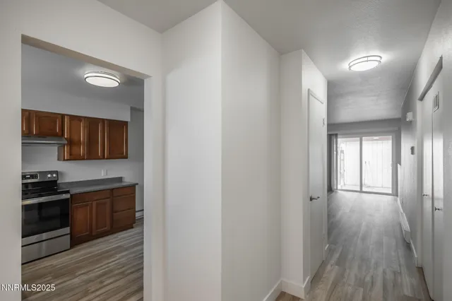 a view of a room with a ceiling fan and wooden floor