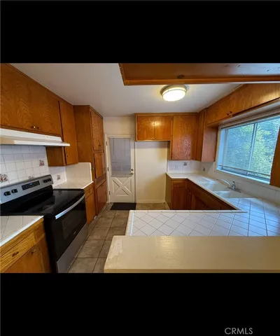 a kitchen with stainless steel appliances wooden cabinets and a counter top space