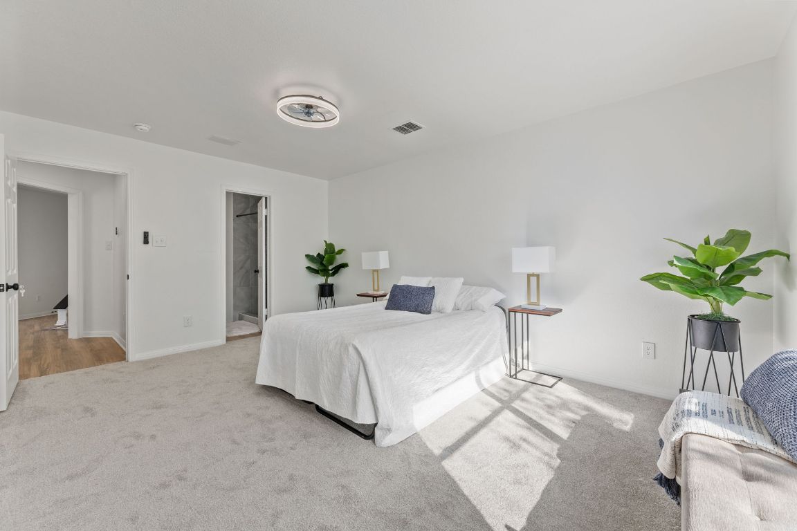 2127 Redwing Way Round Rock, TX 78664 - Photo 13 of 33 Bedroom with light carpet and ensuite bath