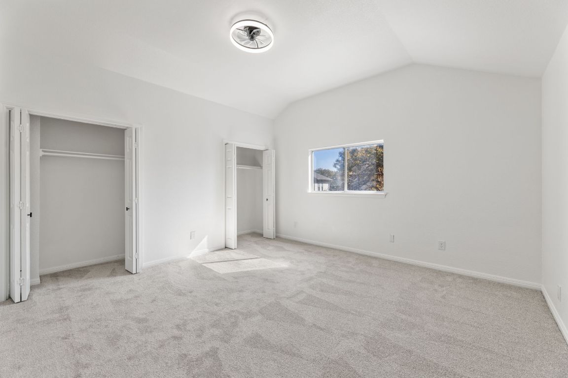 2127 Redwing Way Round Rock, TX 78664 - Photo 17 of 33 Second Bedroom with multiple closets, vaulted ceiling, and light carpet
