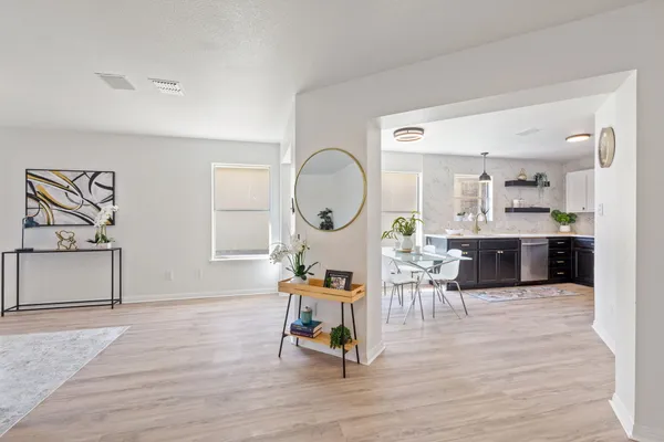 a living room with furniture a wooden floor and a large window