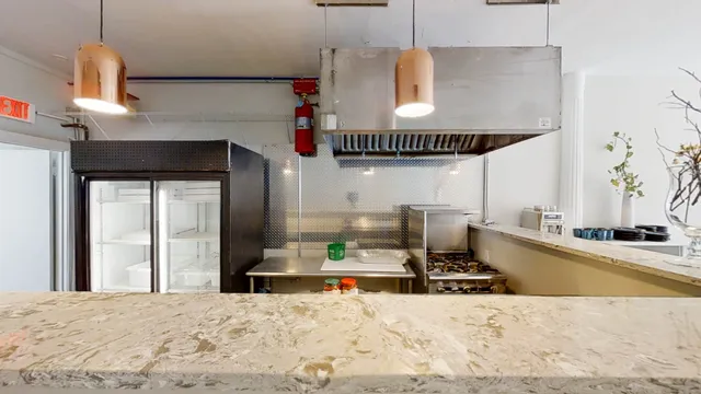 a kitchen with stainless steel appliances granite countertop a sink and a refrigerator