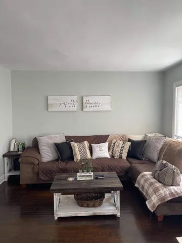 an empty room with wooden floor chandelier fan and windows