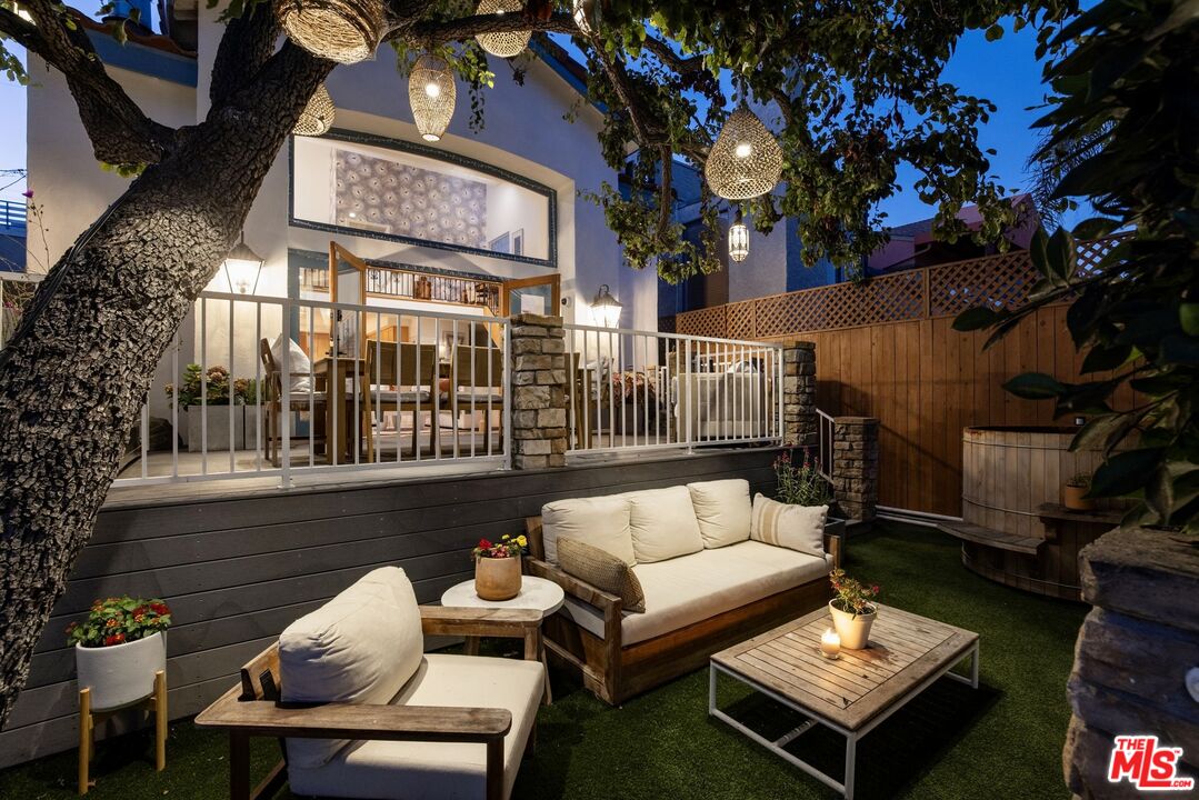 a view of a patio with couches table and chairs and potted plants