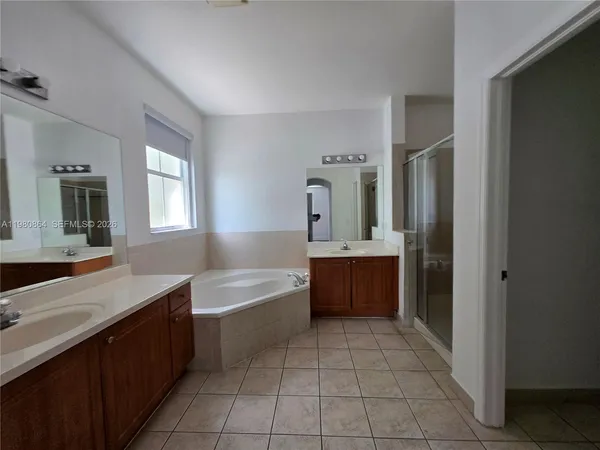 a large bathroom with a double vanity sink a mirror and a bathtub