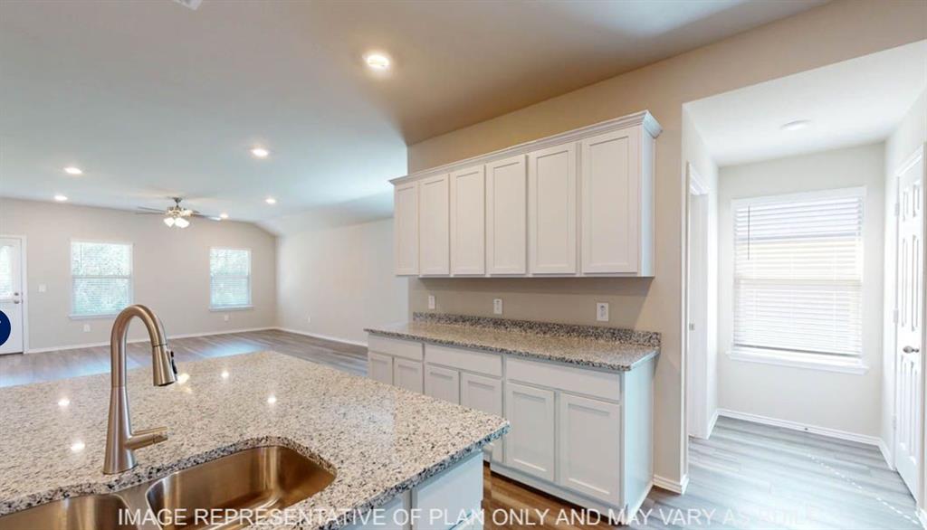 10204 Neptune Court Waco, TX 76708 - Photo 5 of 20 Kitchen island with a stainless steel undermount sink and a gooseneck faucet