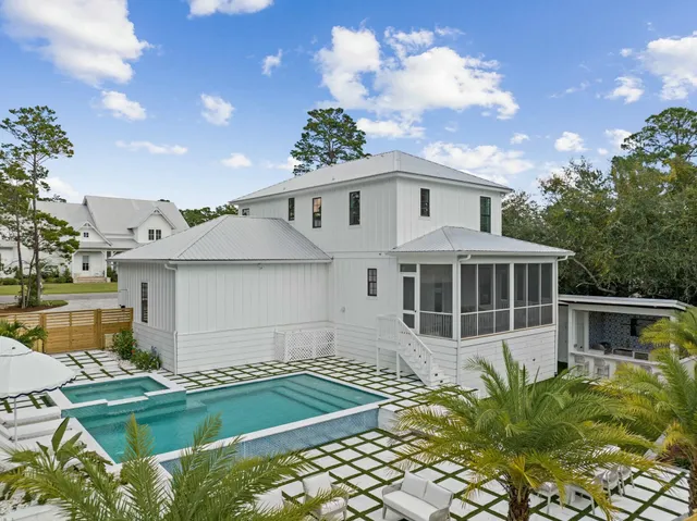 a living room with furniture a flat screen tv and kitchen view