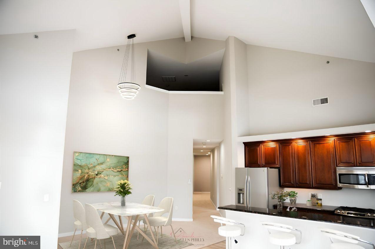 528 Carson Terrace Huntingdon Valley, PA 19006 - Photo 5 of 43 a kitchen with stainless steel appliances a stove a refrigerator a sink and chairs