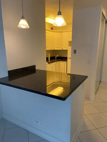 en suite bathroom with a granite countertop sink and a mirror