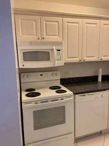 a kitchen with white cabinets and white appliances