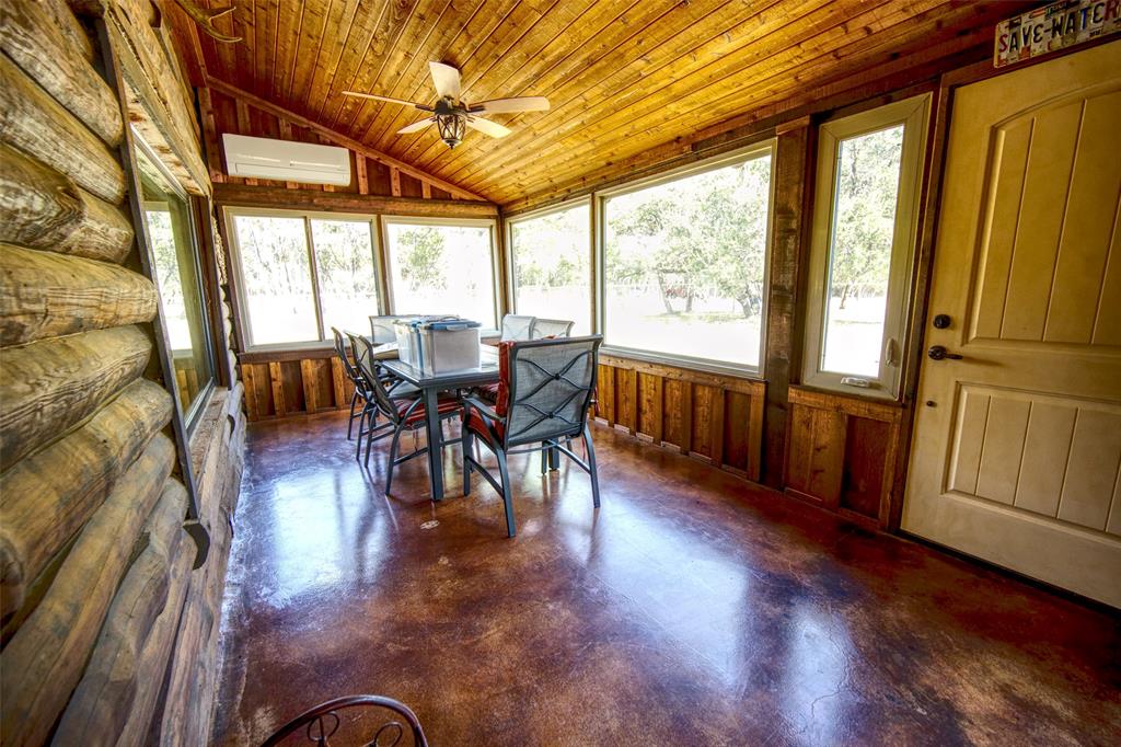 2525 Dodson Pr Road Gordon, TX 76453 - Photo 15 of 31 Sunroom / solarium with lofted ceiling, concrete floors, wooden ceiling, wooden walls, and an AC wall unit