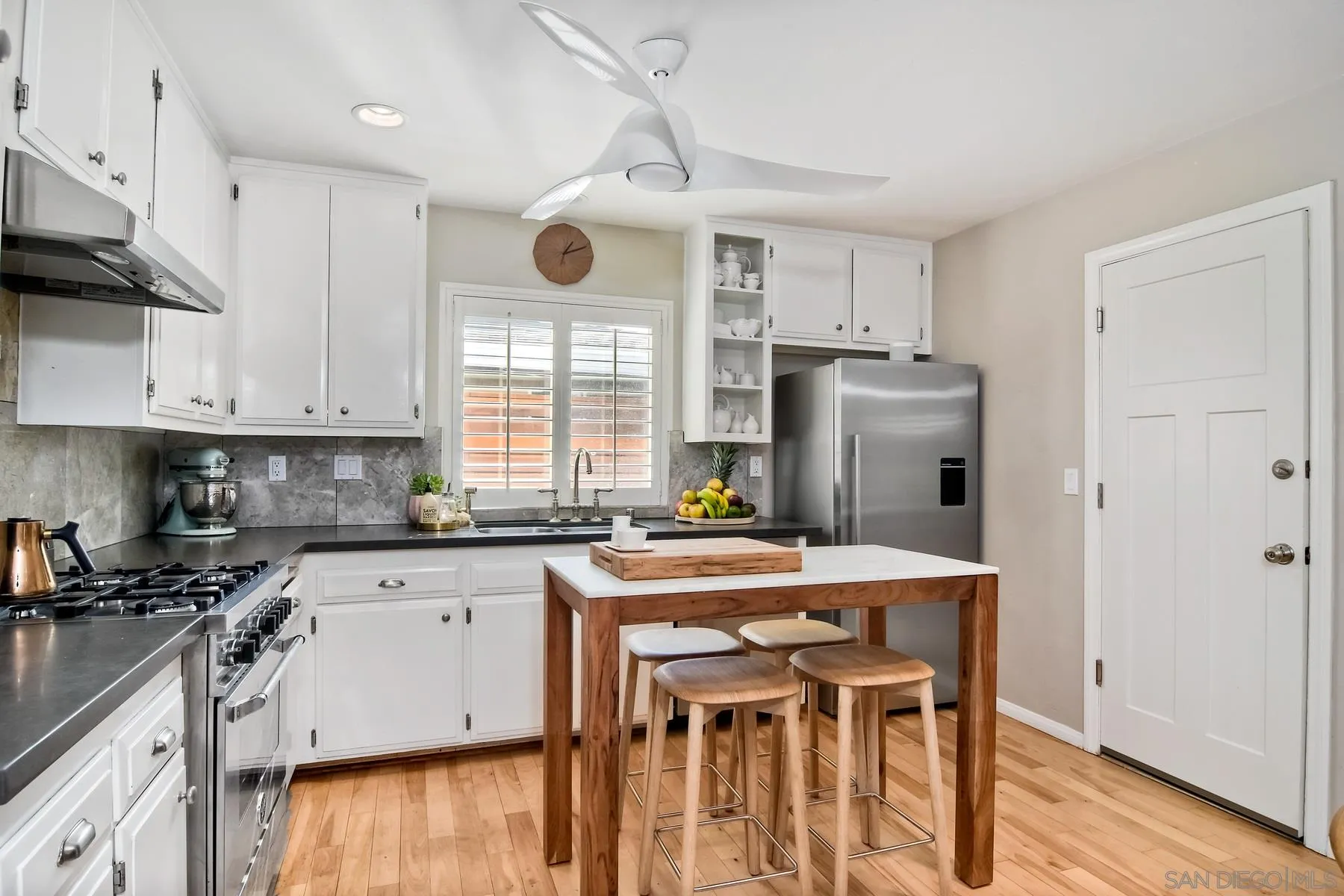 1161 Balour Drive Encinitas, CA 92024 - Photo 4 of 26 a kitchen with a table chairs refrigerator and microwave