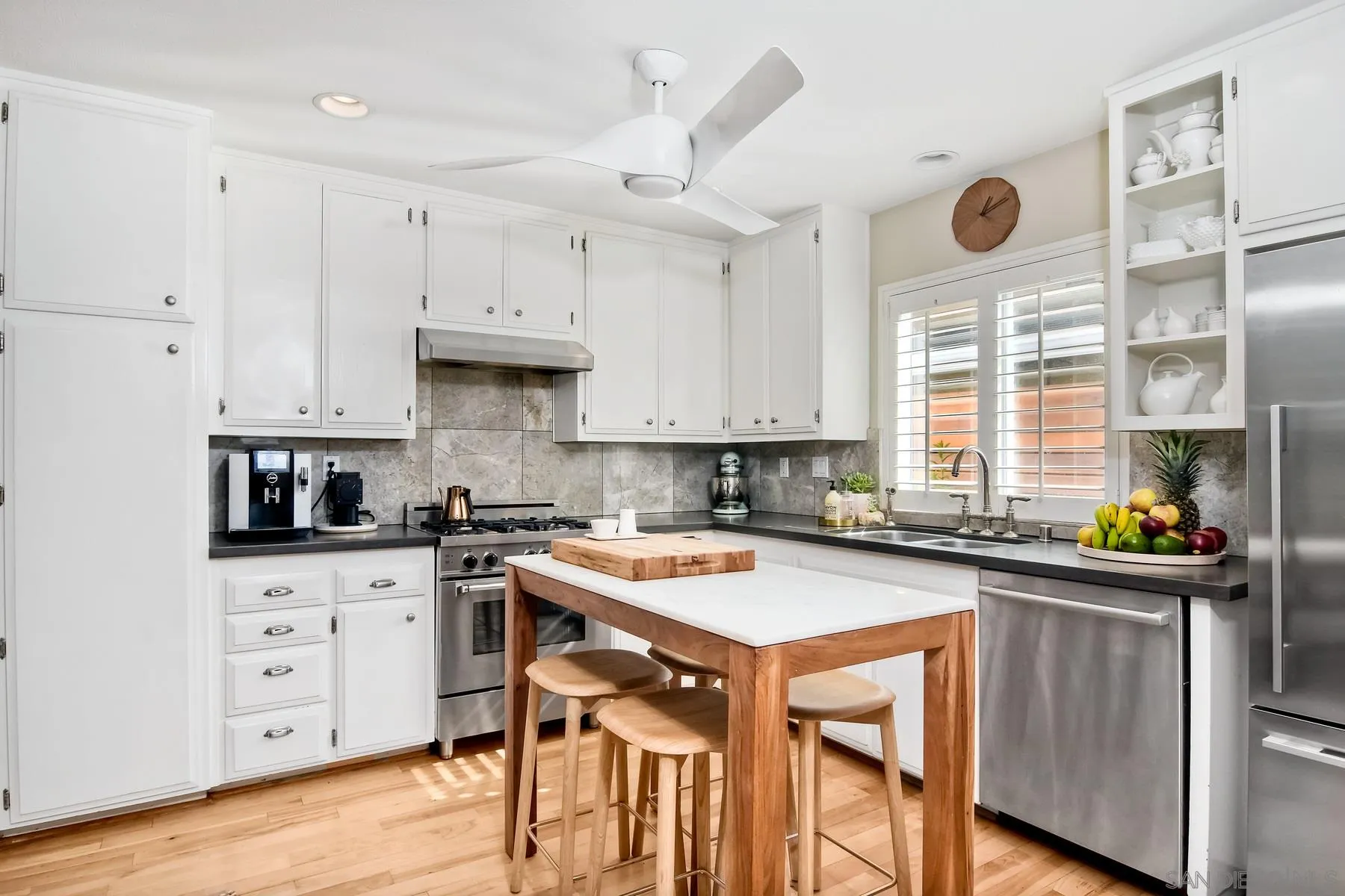 1161 Balour Drive Encinitas, CA 92024 - Photo 6 of 26 a kitchen with stainless steel appliances granite countertop a stove top oven a sink a dining table and chairs with wooden floor