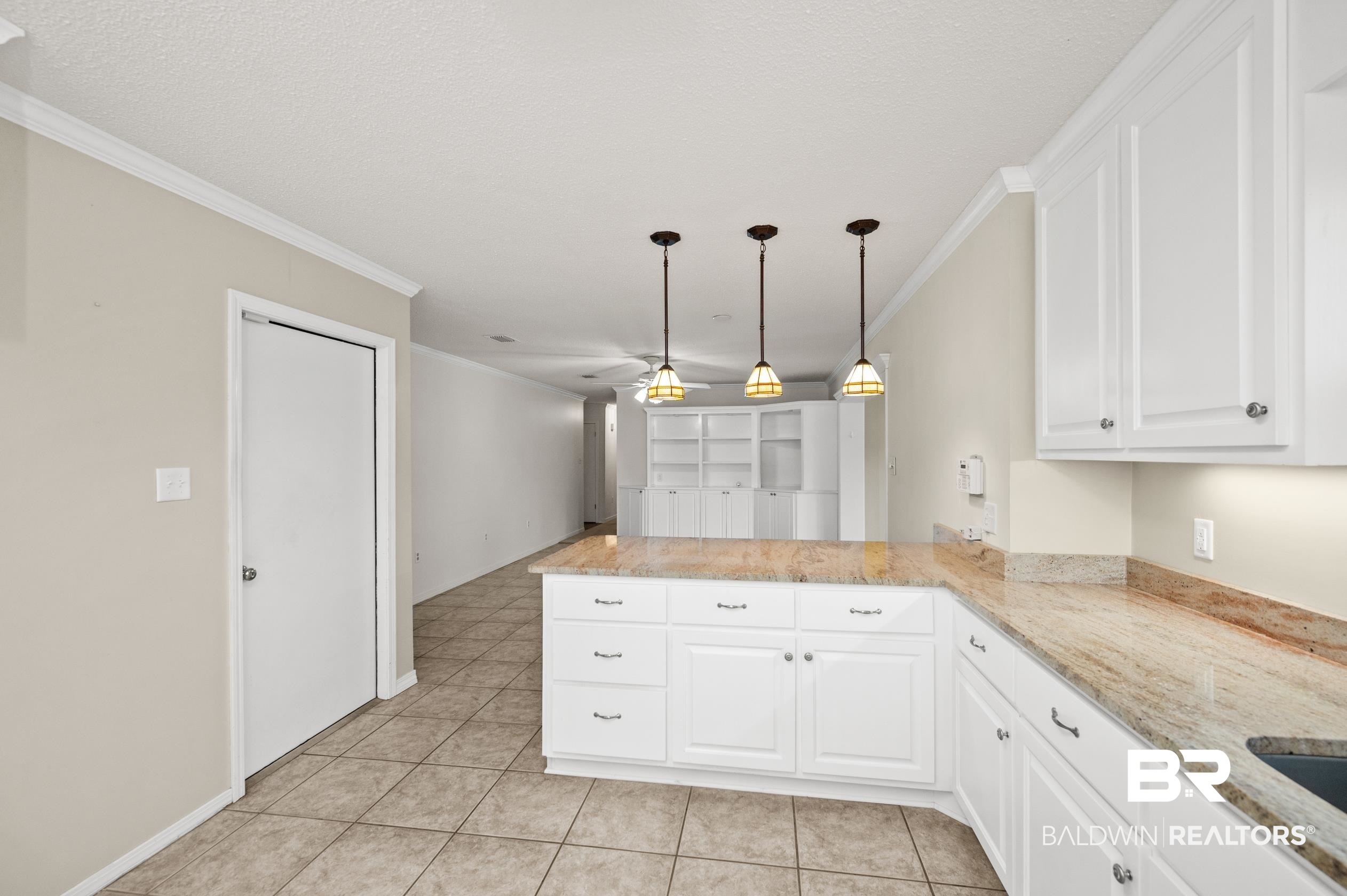 303 West Palm Avenue Foley, AL 36535 - Photo 7 of 32 Kitchen with kitchen peninsula, ornamental molding, and light tile patterned floors