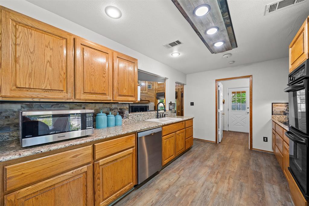 881 Wild Road Van Alstyne, TX 75495 - Photo 15 of 40 a large kitchen with stainless steel appliances granite countertop a stove a sink and a refrigerator