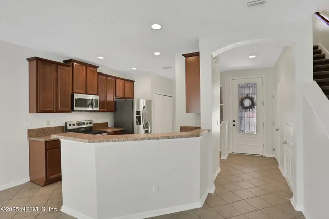 a view of kitchen with refrigerator and microwave