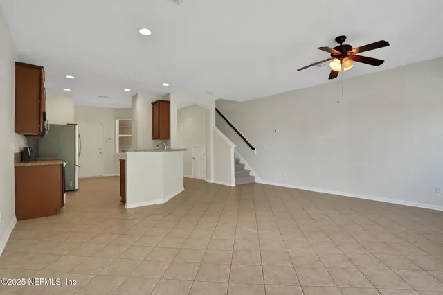 an empty room with windows and a ceiling fan