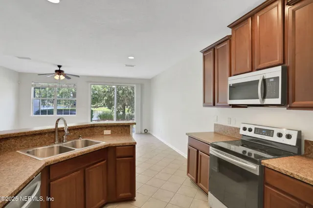 a kitchen with stainless steel appliances granite countertop a refrigerator a stove top oven a sink and dishwasher