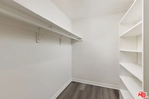 a view of walk in closet with empty racks