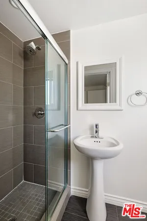 a bathroom with a sink shower and a mirror