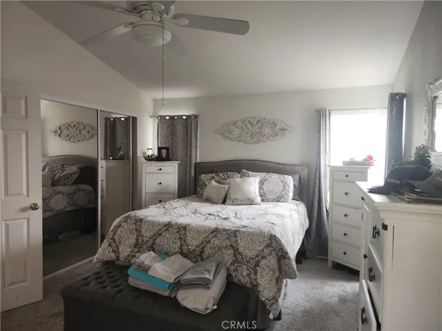 a bedroom with a bed and a refrigerator