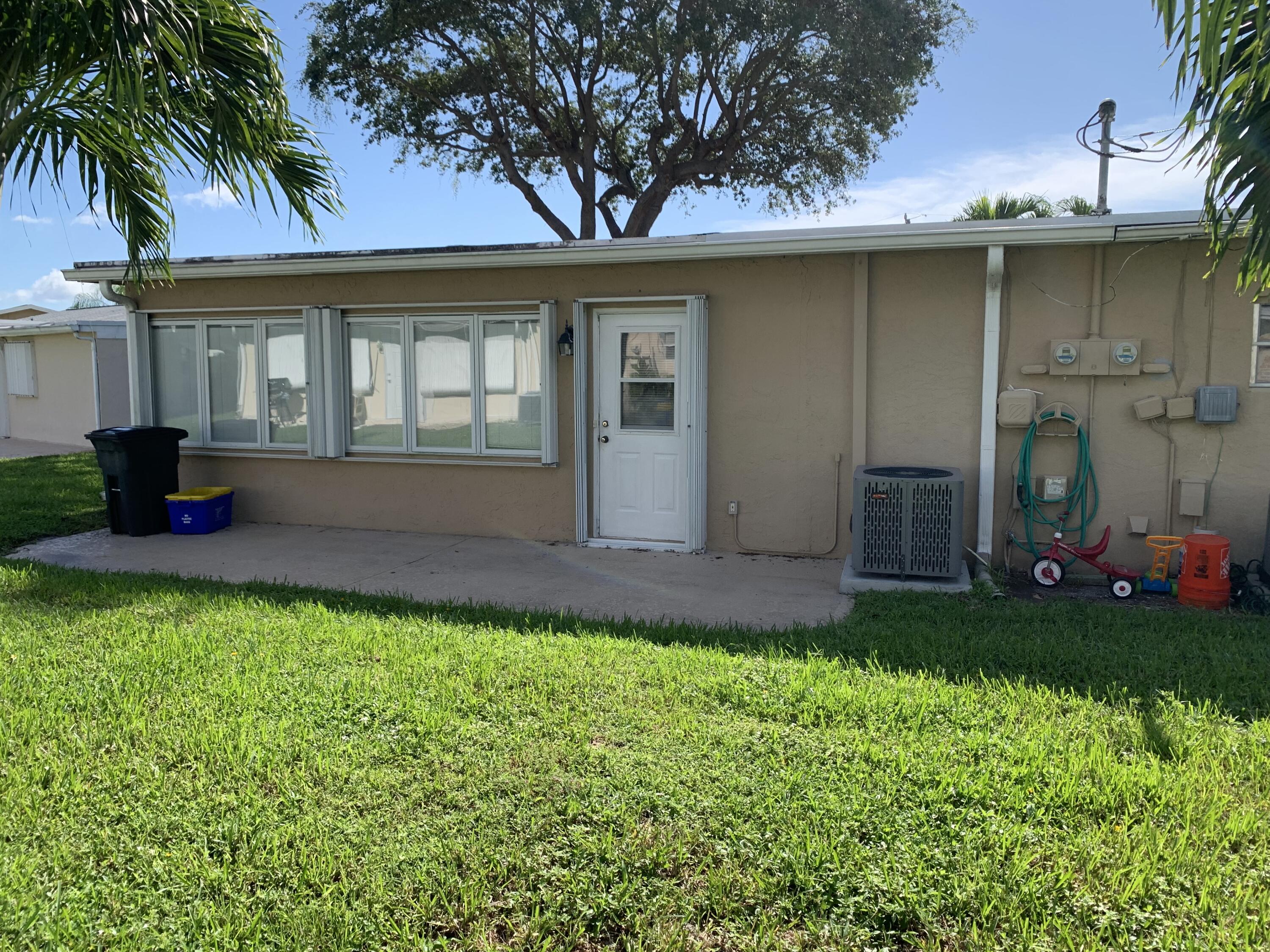 2822 Duke Lane Delray Beach, FL 33445 - Photo 12 of 12 a front view of house with yard and outdoor seating