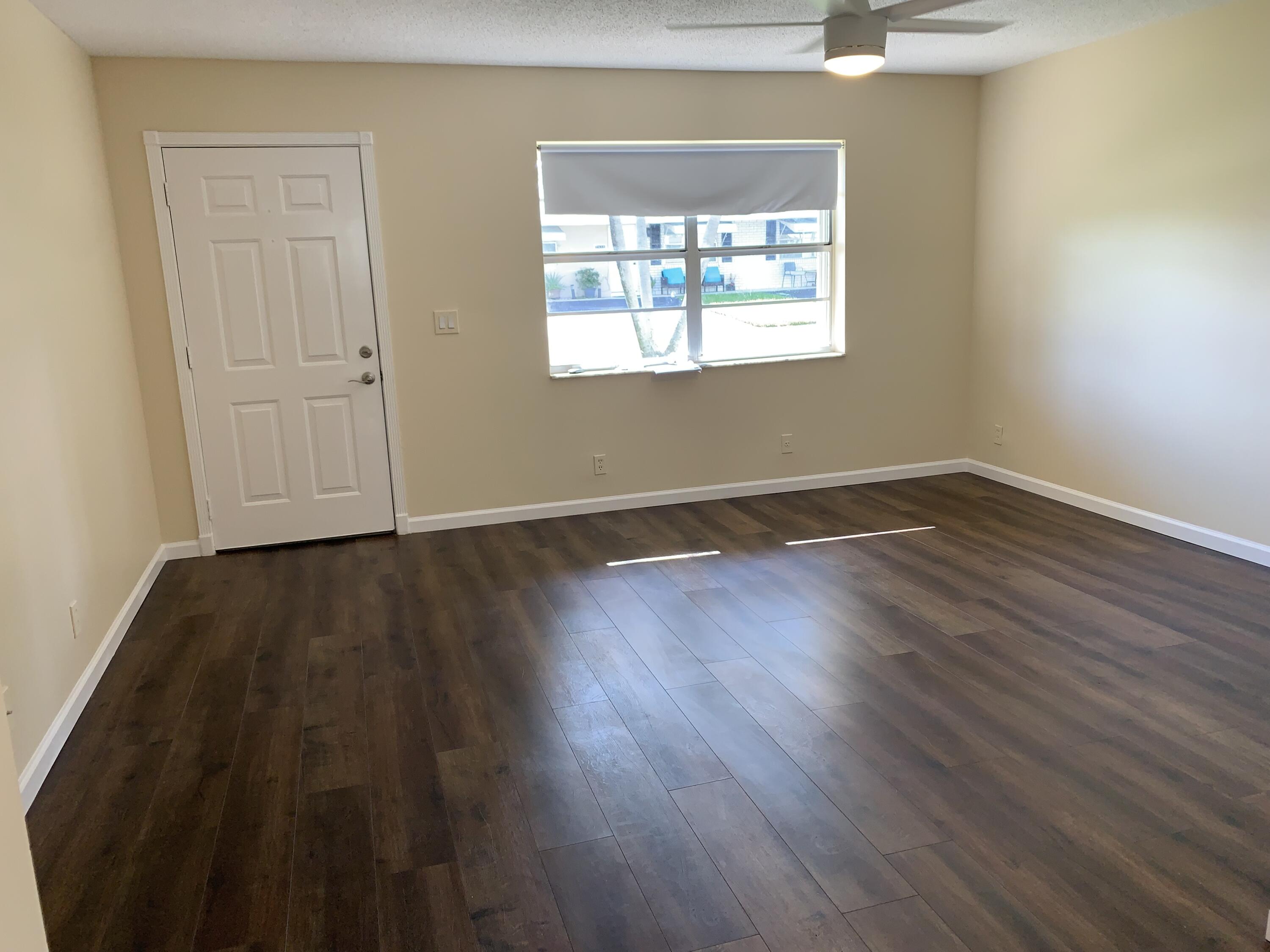 2822 Duke Lane Delray Beach, FL 33445 - Photo 3 of 12 an empty room with wooden floor and windows