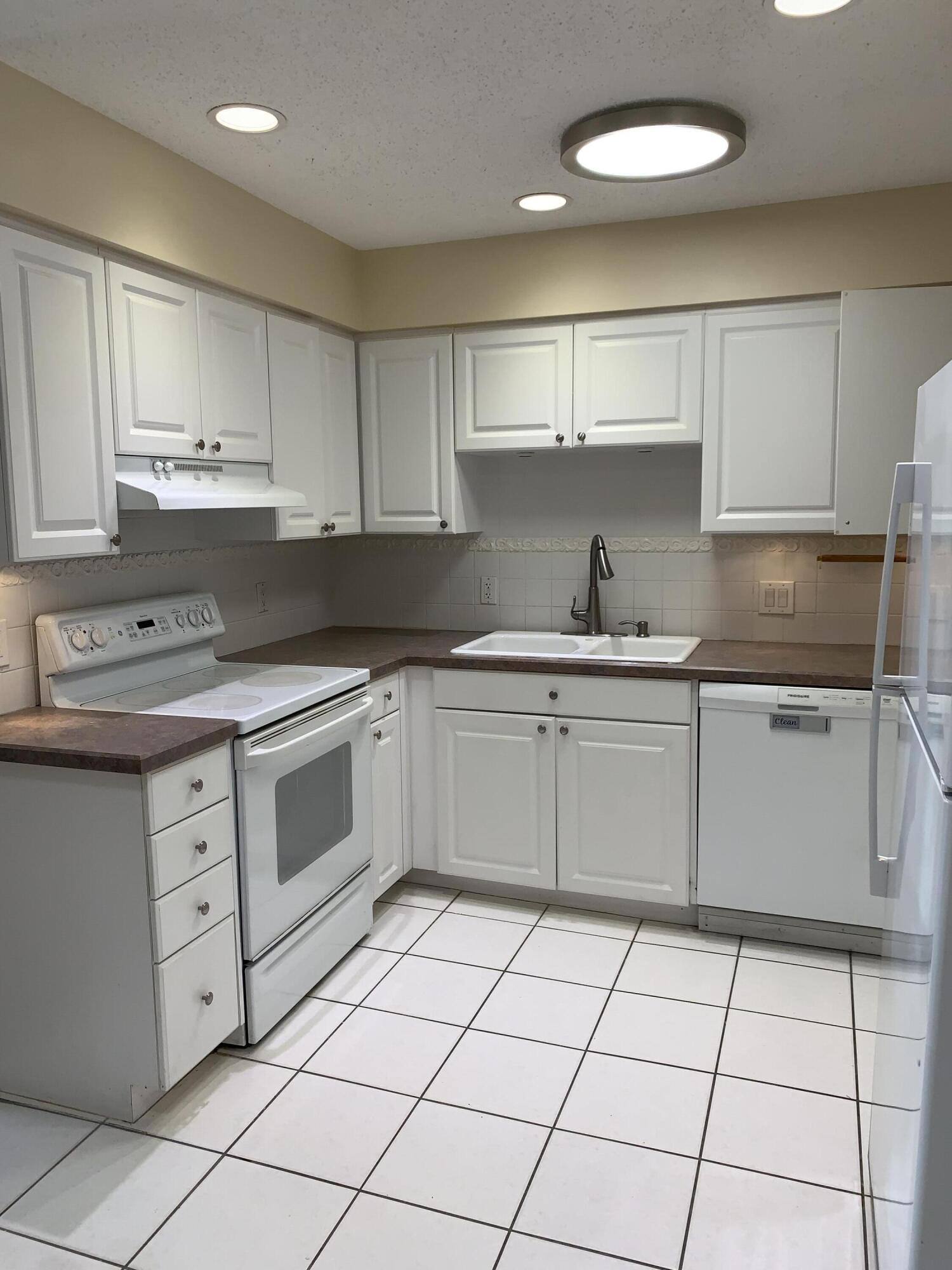2822 Duke Lane Delray Beach, FL 33445 - Photo 5 of 12 a kitchen with a stove sink and cabinets