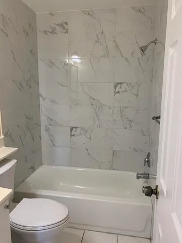 a bathroom with a toilet and a bath tub