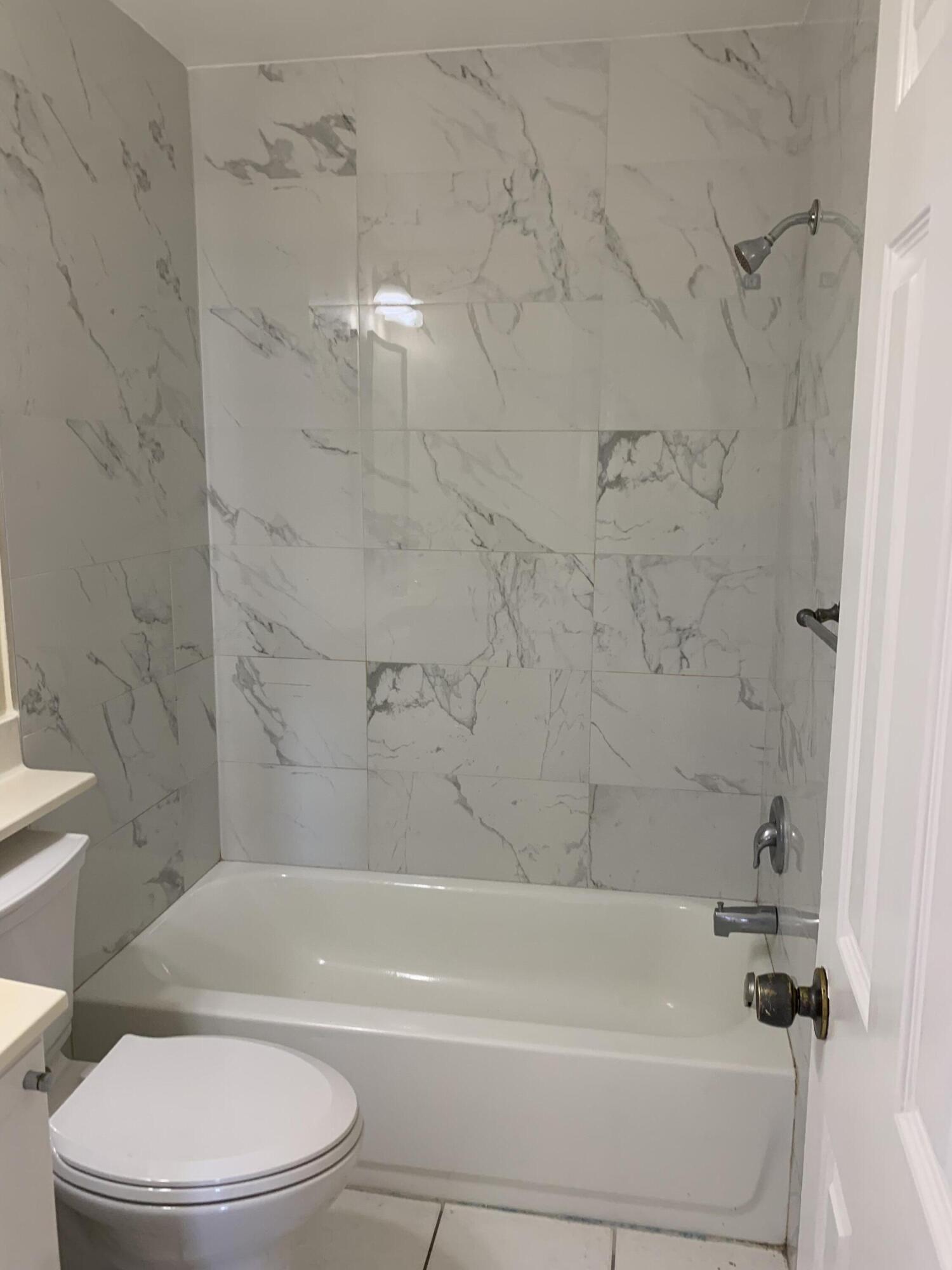 2822 Duke Lane Delray Beach, FL 33445 - Photo 10 of 12 a bathroom with a toilet and a bath tub