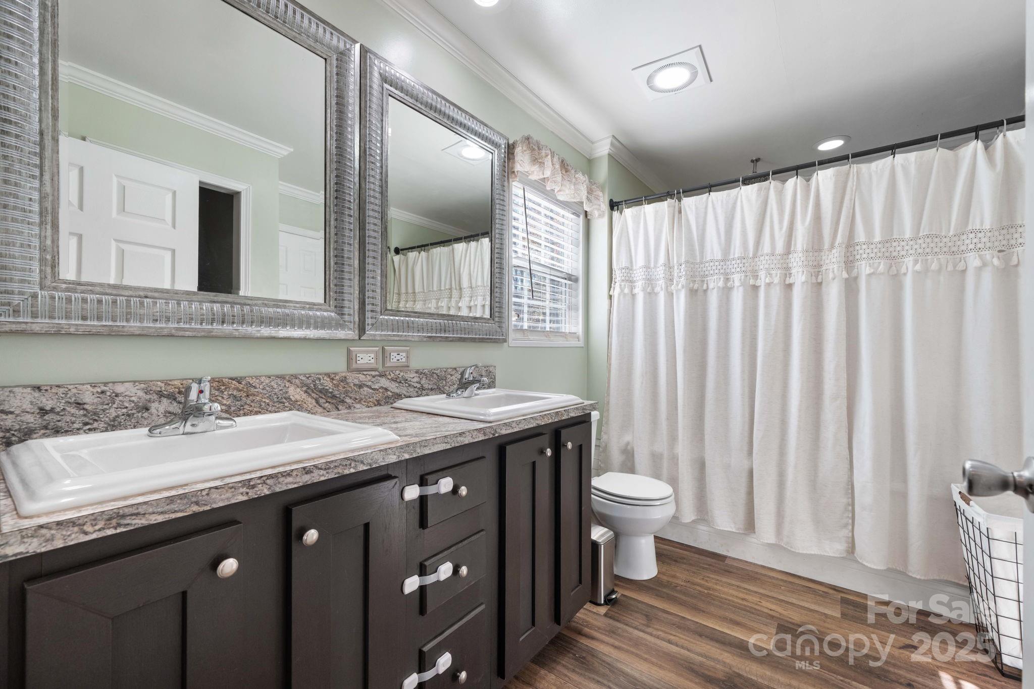 2603 Setzers Gap Road Lenoir, NC 28645 - Photo 15 of 29 a bathroom with a granite countertop sink a toilet and a mirror