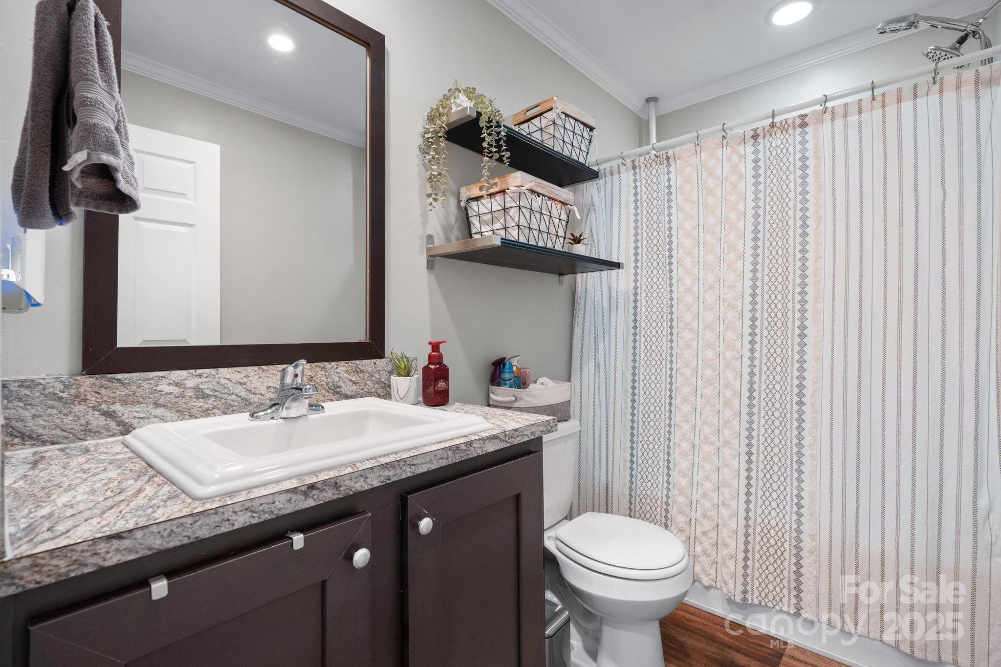 2603 Setzers Gap Road Lenoir, NC 28645 - Photo 17 of 29 a bathroom with a granite countertop sink and a toilet