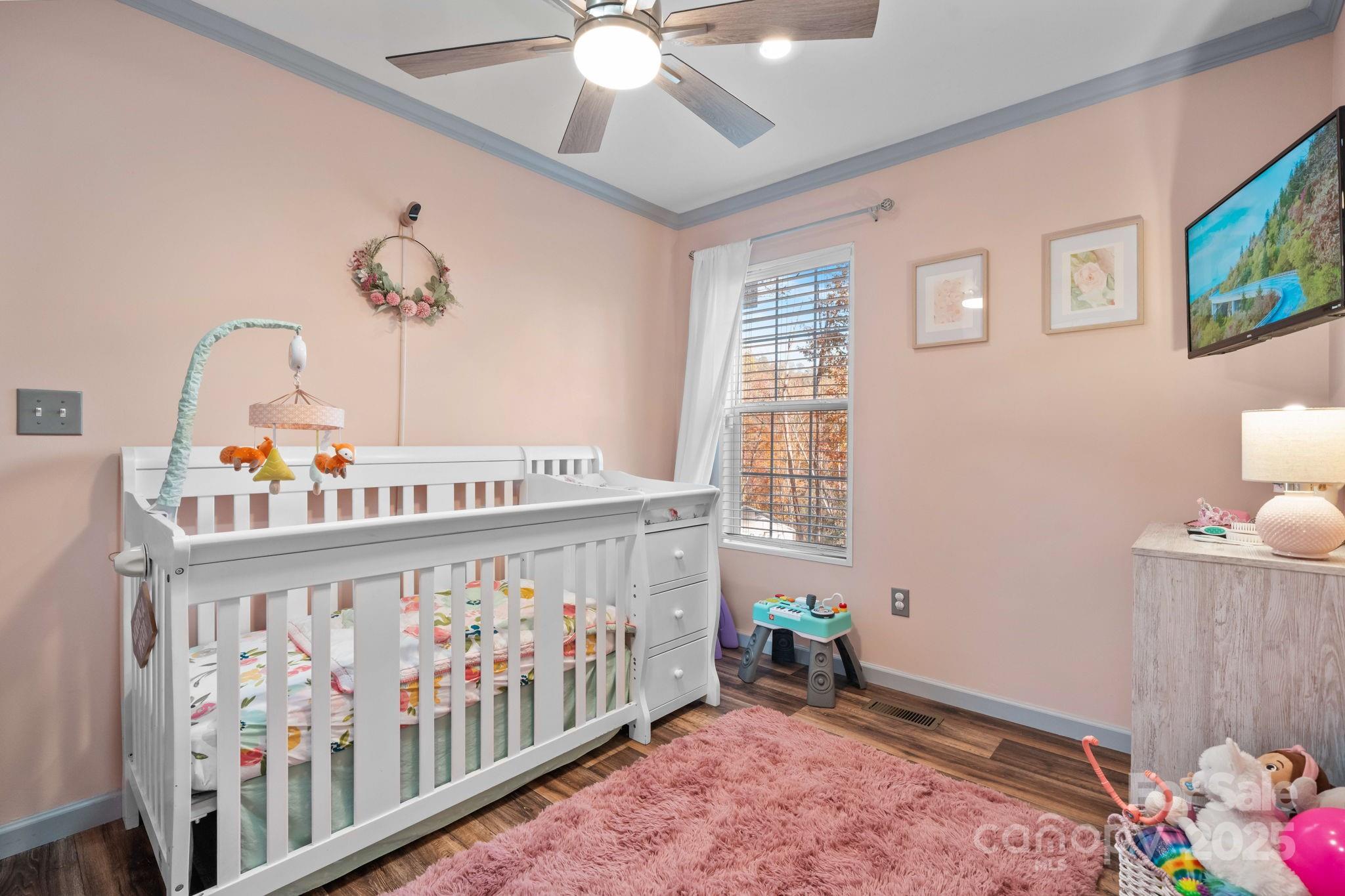 2603 Setzers Gap Road Lenoir, NC 28645 - Photo 18 of 29 a bedroom with furniture a baby crib and a chandelier
