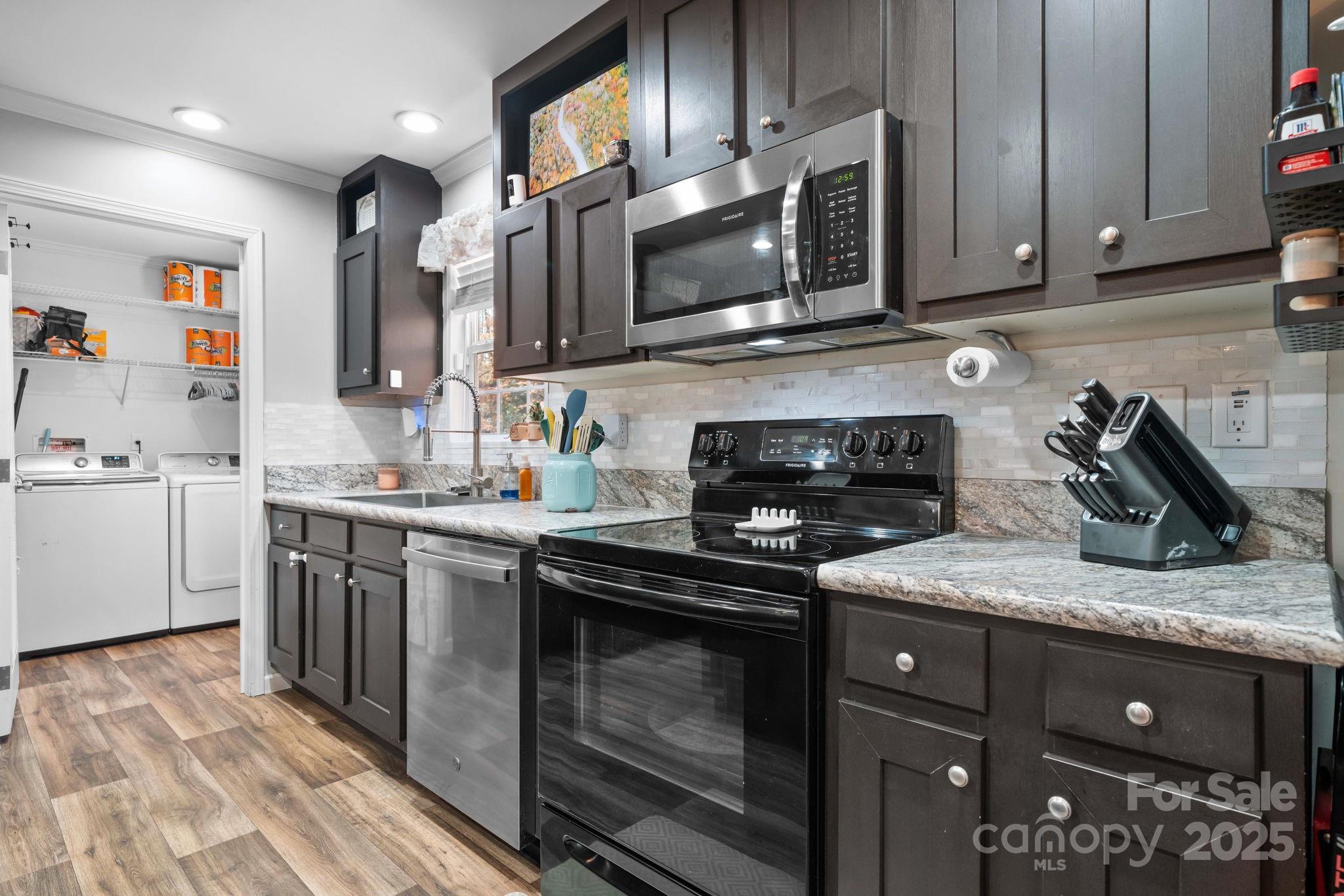 2603 Setzers Gap Road Lenoir, NC 28645 - Photo 10 of 29 a kitchen with stainless steel appliances granite countertop a sink a stove a microwave and cabinets